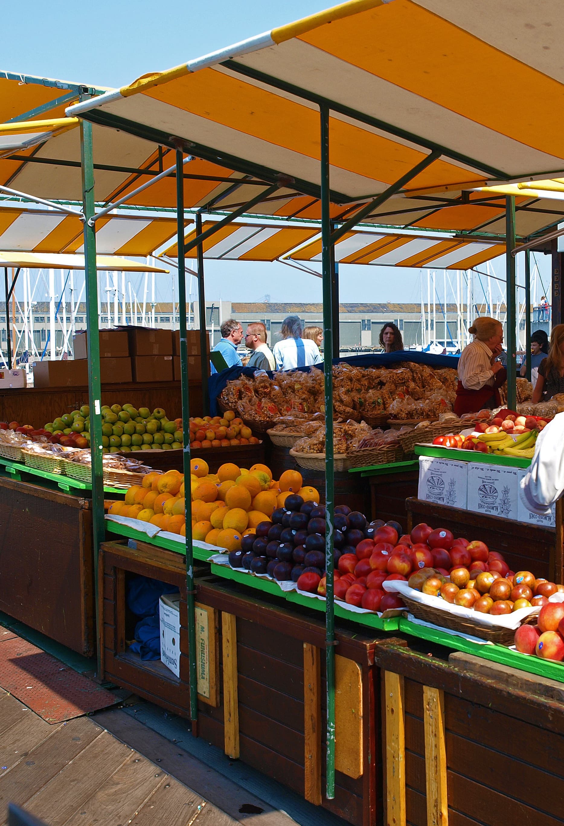 En la imagen se ve un puesto de fruta en un puerto
